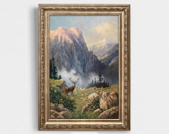 May include: A framed painting of a mountain landscape with a deer standing in the foreground. The mountains are a light blue and gray color, and the sky is a light blue color. The deer is a brown color with large antlers.