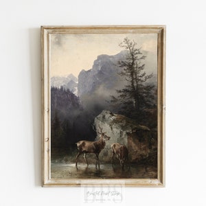 Puede incluir: Una pintura vintage de un paisaje de monta&ntilde;a con dos ciervos de pie en un arroyo. Las monta&ntilde;as est&aacute;n en el fondo y los ciervos en primer plano. La pintura est&aacute; en un marco de madera.
