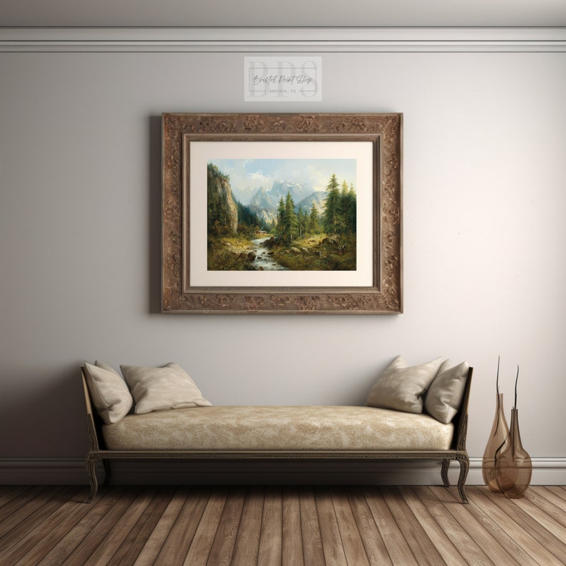 Pu&ograve; includere: Dipinto di paesaggio incorniciato in una cornice di legno marrone ornata, raffigurante una scena di montagna con un fiume, alberi e cielo blu. L'opera &egrave; appesa sopra un chaise longue beige su un pavimento in parquet.