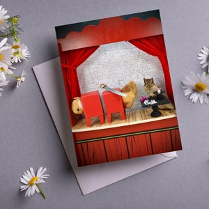 May include: A greeting card featuring a red and white stage set with a squirrel holding a saw and another squirrel sitting at a table with a deck of cards. The card has a red, white, and black color scheme.