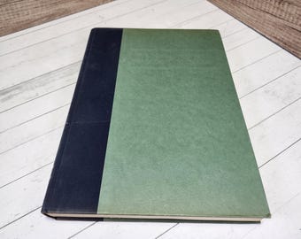 May include: A hardcover book with a dark blue spine and a green cover.