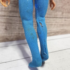 May include: A pair of blue tights with a rip in one leg.