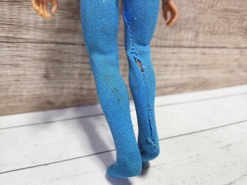 May include: A pair of blue tights with a rip in one leg.