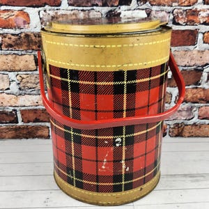 May include: Vintage metal ice bucket with a red plaid pattern and a red handle. The top and bottom are tan with a yellow stitched design. A classic container for beverages.