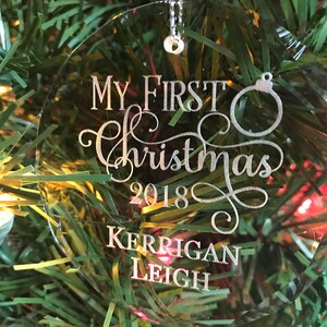 May include: Clear glass Christmas ornament with the text "My First Christmas 2018 Kerrigan Leigh" engraved in silver.