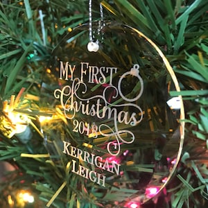 May include: Clear oval Christmas ornament with the text "My First Christmas 2018 Kerrigan Leigh" engraved on it.