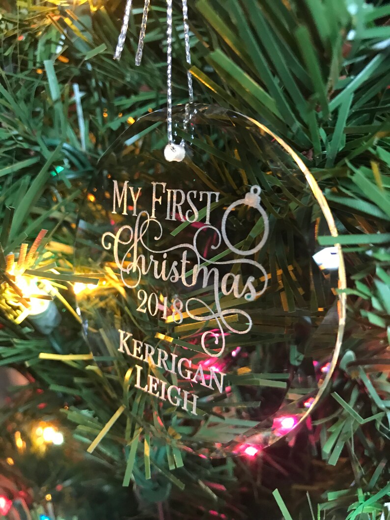 May include: Clear oval Christmas ornament with the text "My First Christmas 2018 Kerrigan Leigh" engraved on it.
