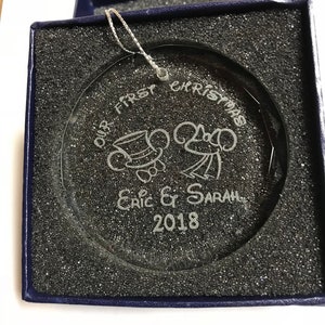 Pu&ograve; includere: Ornamento natalizio in vetro trasparente con design inciso, presentato in una scatola blu. L'ornamento recita "OUR FIRST CHRISTMAS" con personaggi di topi dei cartoni animati e i nomi "Eric & Sarah" e l'anno "2018".