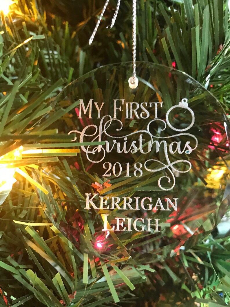 May include: Clear glass Christmas ornament with the text "My First Christmas 2018 Kerrigan Leigh" engraved in silver.