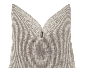 May include: A brown and white patterned throw pillow with a subtle woven texture.