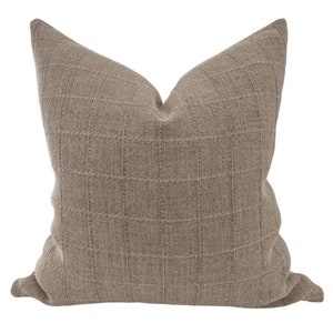 May include: A brown square patterned throw pillow with a soft, textured fabric.