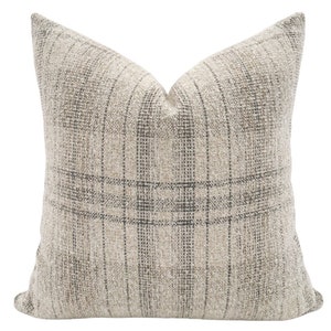 May include: A beige and gray plaid throw pillow with a subtle textured weave.