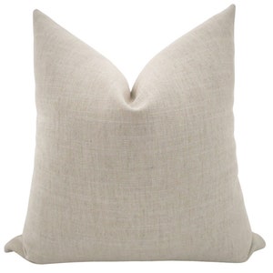 May include: A plain, off-white throw pillow with a linen texture.