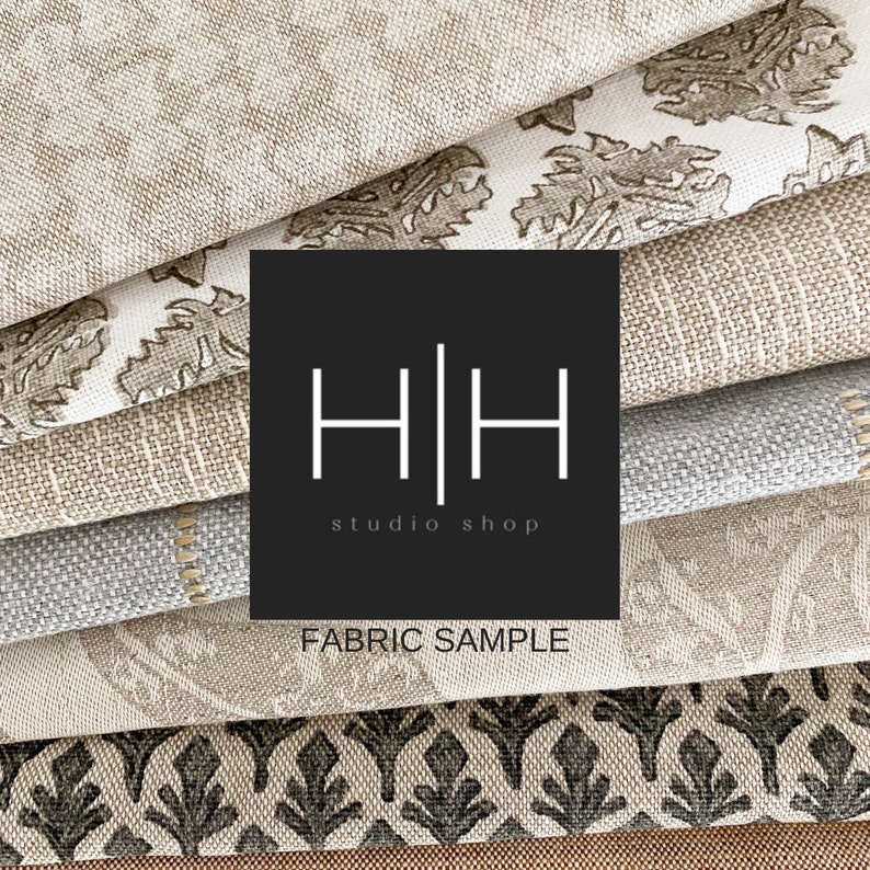 Op de afbeelding: Een stapel stofstalen in verschillende patronen en kleuren, waaronder beige, bruin, grijs en zwart. De stofstalen zijn in een verspringend patroon gerangschikt. Een zwart vierkant met de tekst "H|H studio shop" en "FABRIC SAMPLE" bevindt zich in het midden van de afbeelding.