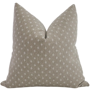 May include: A beige throw pillow with a white geometric pattern.