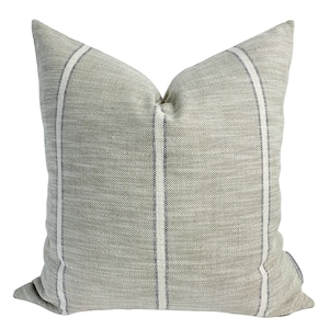 May include: A grey and white striped cushion with a subtle texture. The cushion has a simple, modern design.
