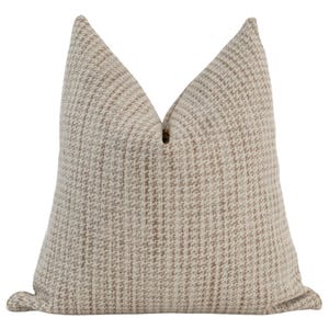 May include: A beige and brown patterned throw pillow with a square shape.