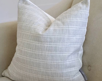 May include: A gray and white striped throw pillow with a white border and a "KICHLER HOME" label on the bottom right corner.