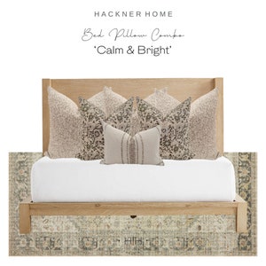 May include: A wooden bed frame with a white mattress and a variety of patterned pillows in shades of beige and brown. The pillows are arranged in a symmetrical pattern on the bed. The bed is sitting on a patterned rug with shades of green, blue, and beige. The text 'Bed Pillow Combo 'Calm & Bright' is written above the bed.