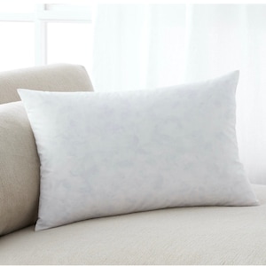 May include: A white rectangular pillow with a subtle marbled pattern, resting on a light beige couch.