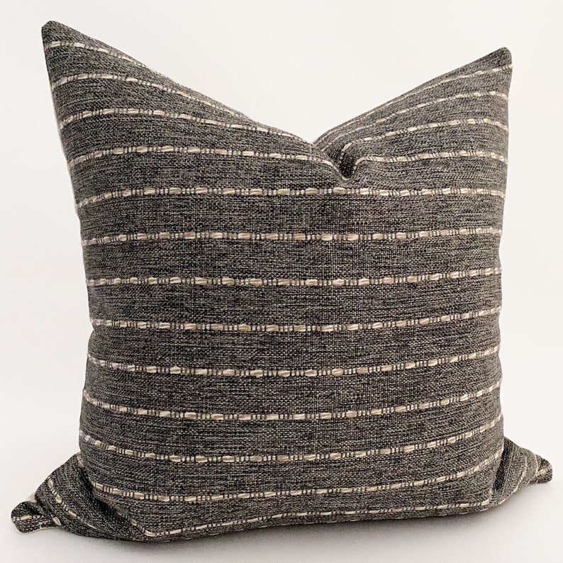 May include: A gray and white striped throw pillow with a subtle woven texture. The pillow is made of a soft, comfortable fabric and is perfect for adding a touch of style to any room.