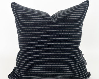 May include: Black and white striped throw pillow with a subtle sheen. The pillow is made of a soft, textured fabric.