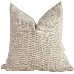 May include: A cream-colored throw pillow with a textured woven fabric.