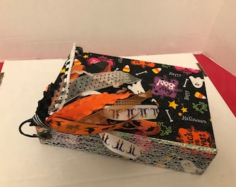May include: A black and white Halloween-themed scrapbook with orange, white, and black ribbons. The cover features a black background with white ghosts, stars, and candy corn. The text "Happy Boo!" and "Happy Halloween" are printed on the cover.