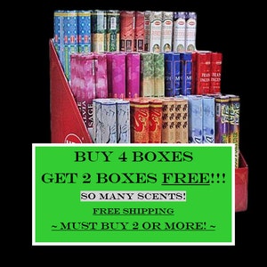 May include: A display of incense boxes in various colours, including blue, pink, red, and green. The boxes are arranged in a tiered display with a red cardboard backing. A green sign with white text reads "BUY 4 BOXES GET 2 BOXES FREE!!!"
