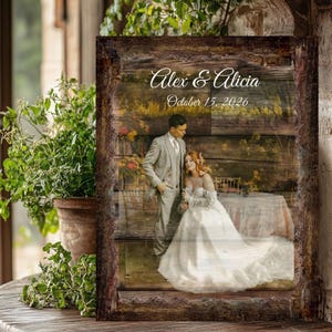 May include: A rectangular wooden sign featuring a printed photograph of a couple in wedding attire. The text Alex & Alicia and October 15, 2026 is printed in white script and serif fonts. The sign has a dark, rustic, textured wood grain border.