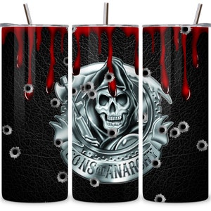 May include: A stainless steel tumbler with a black leather background and a silver skull with the words "Sons of Anarchy" around it. The skull has bullet holes and there are blood drips down the side of the tumbler.