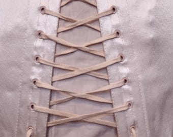 May include: A light pink satin corset with white lacing and a white ribbon tie at the bottom.