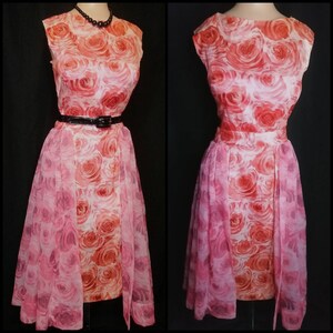May include: A vintage pink and orange floral dress with a sheer overlay. The dress has a fitted bodice and a full skirt. It features a black belt and a sleeveless design.