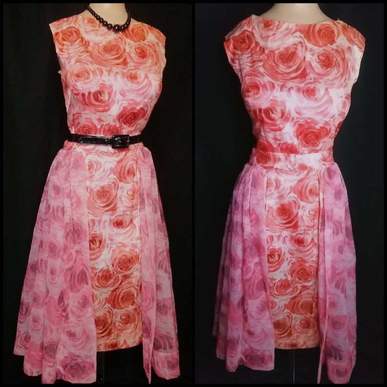 May include: A vintage pink and orange floral dress with a sheer overlay. The dress has a fitted bodice and a full skirt. It features a black belt and a sleeveless design.
