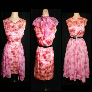 May include: Three sleeveless dresses with a pink and red rose print. The dresses have a fitted bodice and a full skirt. The dress on the left has a sheer overlay. The dress in the middle has a pink bow at the neck. The dress on the right has a black belt.