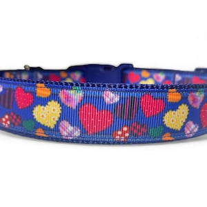 Op de afbeelding: Een blauwe hondenriem met een kleurrijk patchwork hartpatroon.