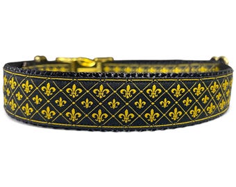 Puede incluir: Collar de perro negro con un patrón de flor de lis dorado.