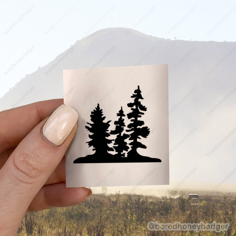 May include: A black silhouette of three pine trees on a white background. The trees are clustered together and have a simple, stylized design.