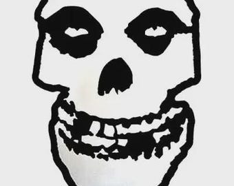 Puede incluir: Ilustración en blanco y negro de una calavera con una amplia sonrisa. La calavera tiene grandes cuencas oculares redondas y una mandíbula prominente.