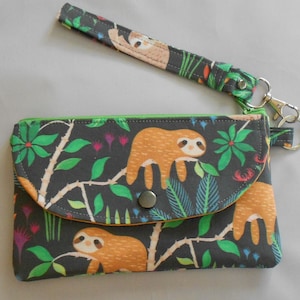 Cartera de tela tipo muñeca con diseño de jungla y bosque de perezosos, 4-1/2" x 7", cierre superior con cremallera y bolsillo frontal a presión, fabricada en EE. UU.