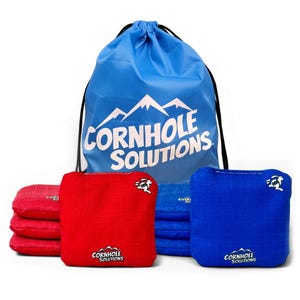 May include: A set of eight square cornhole bags in red and blue, featuring the Cornhole Solutions logo and a rabbit graphic. The bags are accompanied by a blue drawstring storage bag with the white Cornhole Solutions mountain logo printed on it.