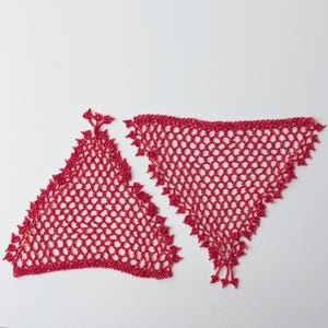 Pode incluir: Duas peças de tecido de renda vermelha de trama aberta, possivelmente um xale ou lenço, são exibidas em um fundo branco. As formas triangulares têm uma textura delicada e perolada e uma borda ondulada. A renda é de cor vermelha vibrante.