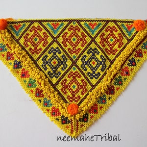 May include: A yellow, blue, red, and orange beaded triangular scarf with a geometric pattern. The scarf has a fringe of yellow beads around the edges.