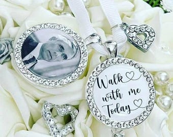 May include: Two silver memorial pendants with crystal accents. One pendant features a black and white photo, the other has the text "Walk with me Today". Both pendants have a heart charm and white ribbon.