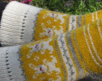 May include: A pair of knitted socks with a yellow, white, and gray striped pattern. The socks have a white cuff and a white pattern on the yellow stripes.