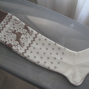 May include: A pair of white knitted knee-high socks with a brown geometric pattern.