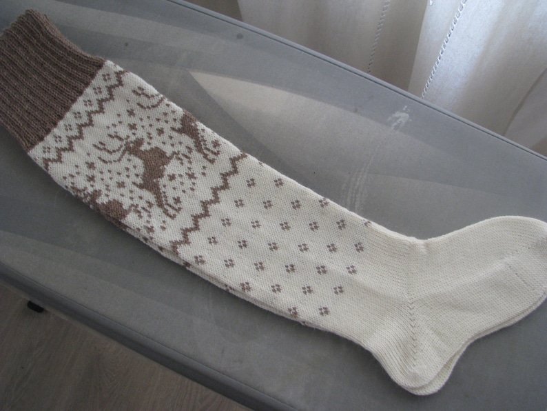 May include: A pair of white knitted knee-high socks with a brown geometric pattern.