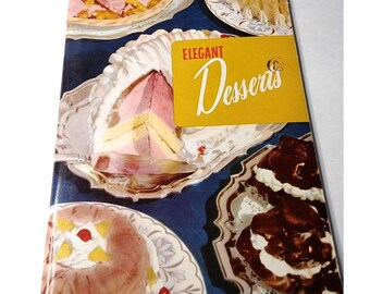 May include: A vintage cookbook titled "Elegant Desserts" with a yellow cover and a picture of three desserts on the front. The desserts include a layered cake, a chocolate dessert with whipped cream, and a fruit dessert with whipped cream.