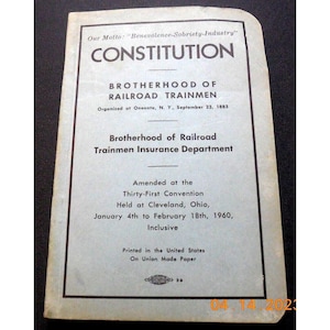 May include: A blue and white document titled "Constitution" with the text "Brotherhood of Railroad Trainmen" and "Brotherhood of Railroad Trainmen Insurance Department". The document states that it was amended at the Thirty-First Convention held in Cleveland, Ohio, from January 4th to February 18th, 1960.