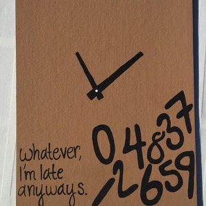 May include: A brown cardboard sign with black paint. The sign has a clock face with hands pointing to the time. The sign also has the text "Whatever, I'm late anyways." and the numbers 0, 4, 8, 3, 7, 1, 2, 6, 5, and 9.